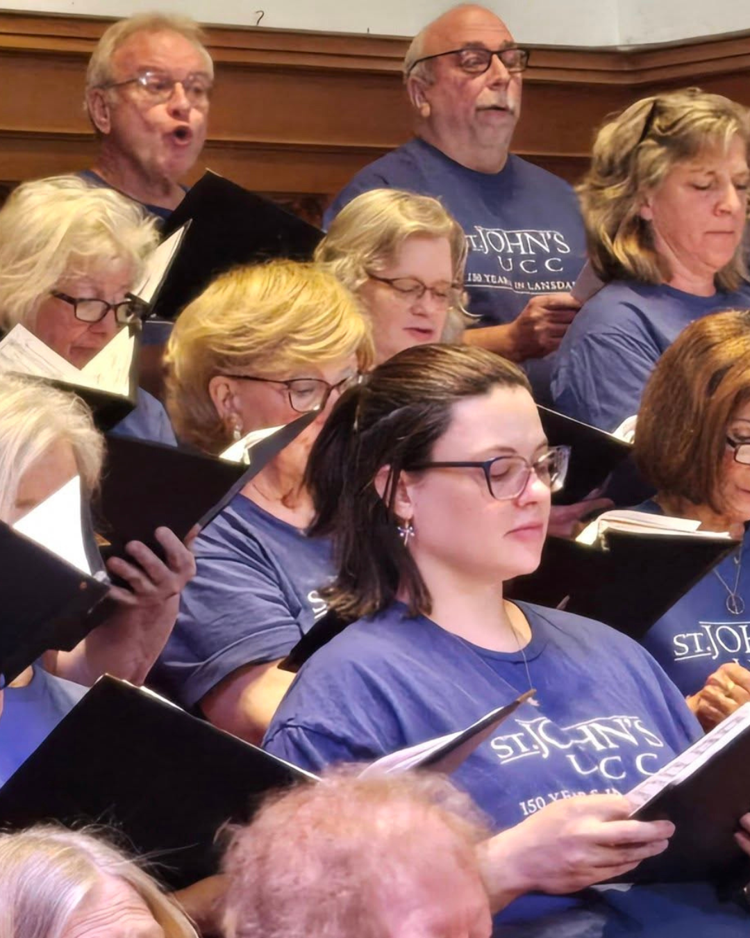 Choir in purple shirts sing